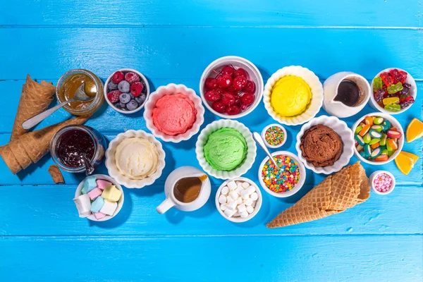 アイスクリームフェスティバルの背景 様々なジェラートのサンデーズの味を持つ夏のアイスクリームビュッフェ 甘いトッピングとスプリンクル コピースペースを表示するための高色の青色の木製の背景 — ストック写真