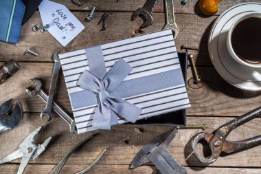 Babalar Günü tebrik kartı geçmişi. Babalar günü konsepti hediye kutusu, aletler ve kravatlar, kahve fincanı, hediye etiketi, baban seni seviyor, kırsal ahşap arka planda fotokopi odası