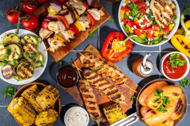 Izgara yaz bbq tabakları. Barda piknik pikniği çeşitli ızgara yiyeceklerle - şiş kebap şiş şiş, ızgara mısır, kızarmış tavuk salata, biftek, sosis, sebze