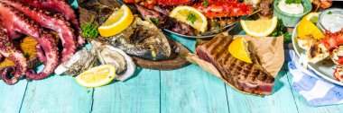 Çeşitli barbekü çeşitleri Akdeniz ızgara gıdaları - balık, ahtapot, karides, yengeç, deniz ürünleri, midye, yaz diyeti bbq parti festivali, kebap, soslar, açık mavi sunne ahşap arka plan
