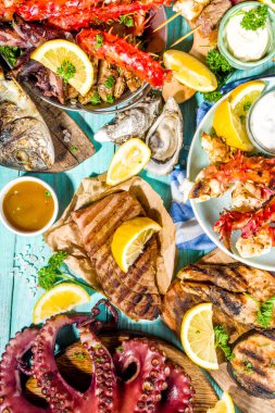 Çeşitli barbekü çeşitleri Akdeniz ızgara gıdaları - balık, ahtapot, karides, yengeç, deniz ürünleri, midye, yaz diyeti bbq parti festivali, kebap, soslar, açık mavi sunne ahşap arka plan