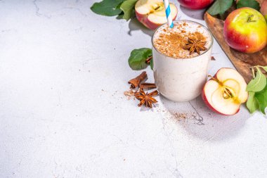 Apple pie smoothie with yogurt, apple slices, oatmeal granola flakes, cinnamon, spices and walnuts. Healthy uatumn breakfast or snack, with fresh raw apples and spices copy space