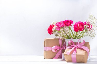 Anneler günü tebrik kartı, davetiye arkaplanı, güzel ranunculus çiçeği buketi, sevimli el işi kağıt hediye paketi ve not: Mutlu anneler günleri, beyaz arkaplanda kopyalama alanı