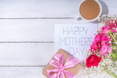 Anneler günü tebrik kartı, davetiye arkaplanı, güzel ranunculus çiçeği buketi, sevimli el işi kağıt hediye paketi ve not: Mutlu anneler günleri, beyaz arkaplanda kopyalama alanı