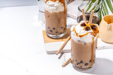 Tapioca boba topları kahve frappe, tapyoka topları ve çırpılmış hindistan cevizi kreması ve karamel soslu Asya modasına uygun soğuk kahve içeceği.