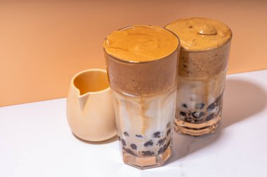 Boba dalgona kahvesi. Süslü Asya kahvesi, çırpılmış kahve ve tapyoka inci topları, güneşli arka planda yaz tatili köpüklü kokteyl bardağı.