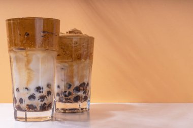 Boba dalgona kahvesi. Süslü Asya kahvesi, çırpılmış kahve ve tapyoka inci topları, güneşli arka planda yaz tatili köpüklü kokteyl bardağı.