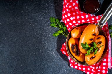 Baharatlı ve otlu ızgara kızarmış sosis, sos soslu, taş masada, kopyalama alanında.