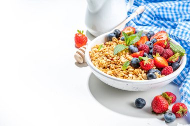 Healthy breakfast granola with fresh berry - strawberry, raspberry, blueberry on white background