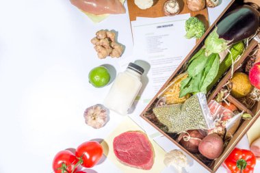 Yemek seti teslimat konsepti. Çeşitli sağlıklı yemek malzemeleri koyun et, sebze, meyve, baharat ve yemek tarifleri. İnternetten şef malzemeleri sipariş etmek, market teslimatı.