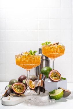 Tutkulu meyve martini kokteyli. Tatlı porno yıldızı alkollü içecek. Taze tutku meyvesi ve limon. Bar aletleri de yer kaplıyor.