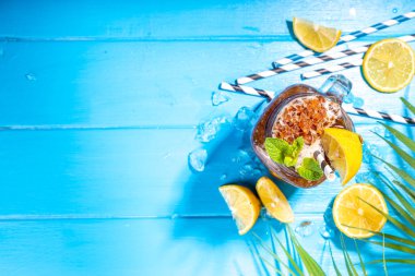 Southern Sweet Tea Slushy. Soğuk yaz çayı buzlu tatlı, ezilmiş buzlu çay ve limon suyu, güneşli mavi ahşap arka plan fotokopi alanı