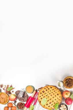 Sonbahar pastası ve kek pişirme arka planı. Tatlı elma, ceviz, kabak kabağı turtaları fırın malzemeleri ve çatal bıçakları, beyaz masa arkaplanı fotokopi alanı