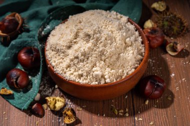 Kestane unu, alışılmadık vegan glütensiz un, taze ve kavrulmuş kestane ile ahşap zemin üzerinde