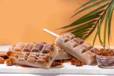 Tapioka latte buzlu şeker. Donmuş tapyoka boba topları kahve frappe, Asya usulü soğuk tapyoka kahvesi, Hindistan cevizi kremalı ve karamel soslu lolipoplar.