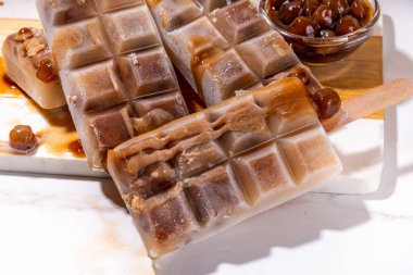 Tapioka latte buzlu şeker. Donmuş tapyoka boba topları kahve frappe, Asya usulü soğuk tapyoka kahvesi, Hindistan cevizi kremalı ve karamel soslu lolipoplar.