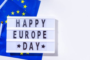 Mutlu Avrupa Günü, basit arkaplan, yazıtlı ışıkkutusu işareti Mutlu Avrupa Günü, Avrupa Birliği bayrakları, beyaz arka plan üst görünümü düz fotokopi alanı