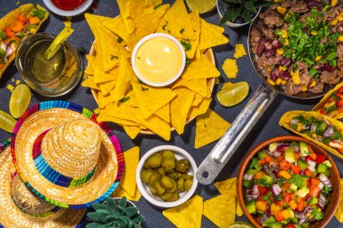 Cinco de mayonez partisi yemeği. Meksika bayramı Cinco de Mayo geleneksel yemekleri, atıştırmalıklar, mısır cipsi, nacho, taco, salsa, sos. Arkadaşlar ve aile ziyafeti arka plan üst görünüm kopyalama alanı