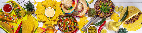Cinco de mayo party food. Mexican holiday Cinco de mayo traditional dishes, snacks, tortilla corn chips, nachos, tacos, salsa, sauces. Friends and family feast background top view copy space