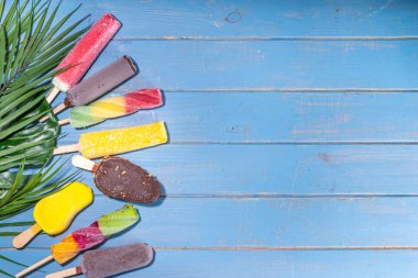 Turkuaz ahşap arka planda dondurmalı dondurma, yaz tatlıları, tatlı, tatil ve tatil geçmişi, çeşitli aromalı lolipoplar - çikolata, vanilya, meyve, gökkuşağı 