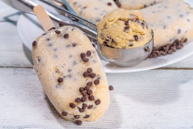 Yenilebilir çiğ kurabiye hamurlu buzlu dondurma. Ev yapımı dondurmalı lolipoplar, dondurulmuş çiğ çiğ kurabiye hamuru ve çikolata parçacıkları, modaya uygun Amerikan yaz tatlıları.