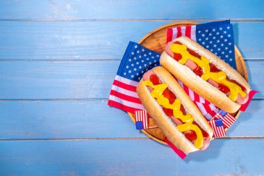 ABD Vatansever Piknik Tatil Sosislileri. Tahta tabakta Amerikan vatansever sosislisi ve Amerikan bayrağı. 4 Temmuz 'da Bağımsızlık Günü, Anma Günü veya Gaziler Günü