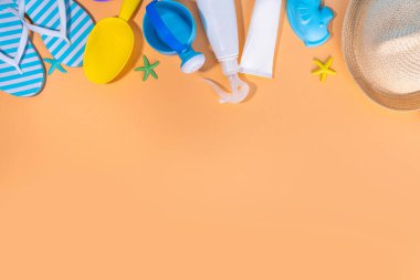 Çocuklar, çocuklar, bebek ve güneş koruması, UV korumalı güneş kremi kozmetikleri. Güneş kremi, güneş kremi, güneş gözlüğü, panama şapkası, kumlu bej arka planda oyuncaklar.