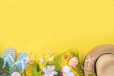 Modayı takip eden sarı yaz tatili, seyahat ve yaz tatili geçmişi. Tropikal yaprakları, çiçekleri, deniz kabukları, deniz yıldızları, parmak arası terlikleri, şapkaları, plaj aksesuarları, üst görünüm kopyalama alanı olan parlak düz yatak.