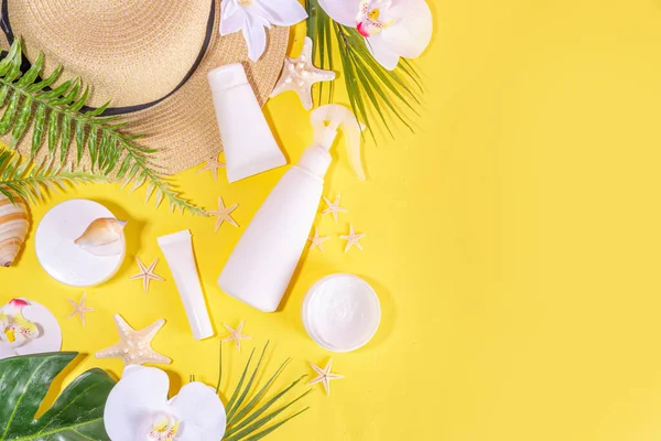 Trendy electric yellow summer cosmetics background. Different skincare, sunscreen cosmetic jars, tubes, moisturizer, cream, serum, masks for face and hands, top view copy space