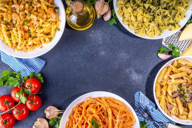 Beyaz fayanslı arka planda farklı soslu makarna seti. Spagetti, farfalle, makarna, deniz ürünleri, ıspanak, karbonara, domates soslu fusilli makarna. İtalyan yemeği, Akdeniz yemeği konsepti