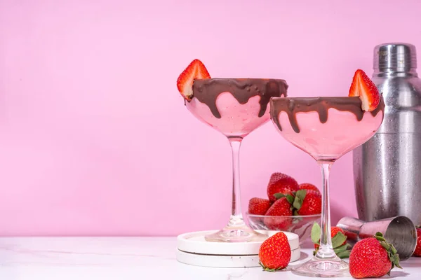 Sweet chocolate strawberry cocktail, cute pink strawberry martini or daiquiri creamy drink, with fresh strawberry garnish and choco drizzles, on high-colored pink background