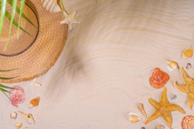 Yaz güneşli kum düzlüklerinde hasır şapkalar, terlikler ve deniz kabukları ile deniz kumu arka planında fotokopi uzayı uzanıyordu.