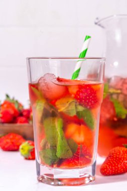 Sürahi ve bardakta ev yapımı çilekli limonata, bir sürü ezilmiş buz, dilimlenmiş böğürtlen ve nane yaprağı, donmuş çilekli sangria, buzlu çay, punç veya mojito ile.