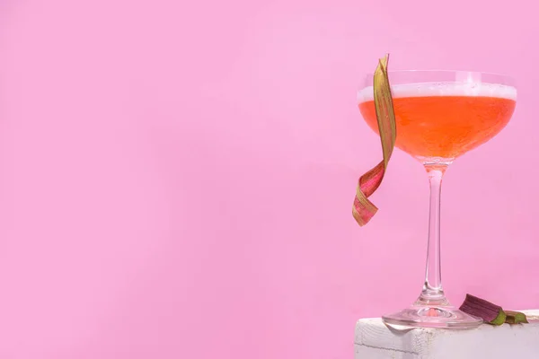 大黄夏季冷李或马提尼鸡尾酒 带粉红大黄的酒 五颜六色背景的碎冰块和酒吧器皿 — 图库照片