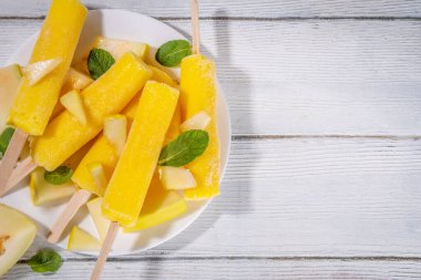  Kavunlu dondurma, tatlı şerbet lolipopu, çubuklarda ev yapımı dondurma, taze kavun dilimleri ve nane yaprakları. 