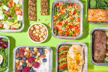 Sağlıklı yemek menüsü, kurye yemek teslimatı beslenme çantası. Biftek eti, tavuk fileto, balık ve sebzeler paketlerde. Günlük yemek diyet planı teslimatı, paket servisi, online sipariş konsepti.