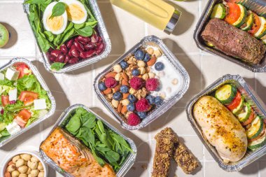 Sağlıklı yemek menüsü, kurye yemek teslimatı beslenme çantası. Biftek eti, tavuk fileto, balık ve sebzeler paketlerde. Günlük yemek diyet planı teslimatı, paket servisi, online sipariş konsepti.