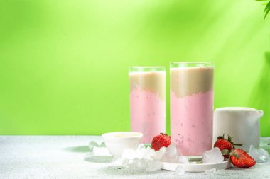 Doğal sağlıklı yaz içeceği. Diyet organik çilek ve matcha latte kokteyli, taze çilek ve buzlu, açık yeşil arka planda.