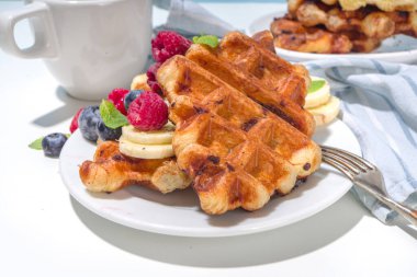 Modern tatlı mahsulü - kruvasan ve waffle karışımı, kabarık waffle ızgarası, böğürtlenli, meyveli çikolata soslu 