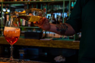 Gerçekçi fotoğraf, bardaki profesyonel barmenin buzlu ve alkollü kokteyl yaparken çekilmiş yakın plan fotoğrafı.