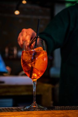 Gerçekçi fotoğraf, bardaki profesyonel barmenin buzlu ve alkollü kokteyl yaparken çekilmiş yakın plan fotoğrafı.