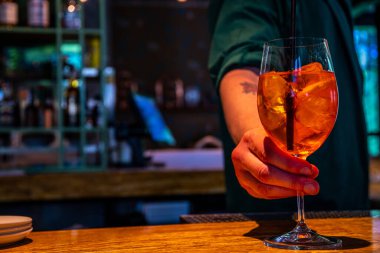 Gerçekçi fotoğraf, bardaki profesyonel barmenin buzlu ve alkollü kokteyl yaparken çekilmiş yakın plan fotoğrafı.