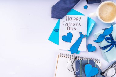 Aksesuar ve dekor, Babalar Günü tebrik kartı, babamın tatil yeri, zarf, kartpostal, bıyık, peçete, kravat, kahve ve mavi arka planda hediye kutusu.