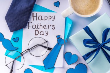 Aksesuar ve dekor, Babalar Günü tebrik kartı, babamın tatil yeri, zarf, kartpostal, bıyık, peçete, kravat, kahve ve mavi arka planda hediye kutusu.