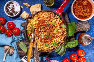 Bol soslu klasik bolonez makarna, dökme demir tavada, geleneksel et soslu İtalyan makarnası parmesan peyniri ve fesleğen yapraklı.