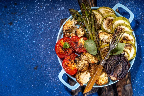 焼き野菜ズッキーニ アスパラガス トマト カリフラワー セラミックパンやプレート上のピーマン ハーブやニンニクと トップビューのコピースペース — ストック写真