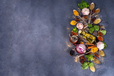 Karanlık arka planda yemek pişirmek için baharatlar. Farklı baharatlar, baharatlar ve otlar kırmızı biber, zerdeçal, tuz, fesleğen, nane, tarçın, sarımsak, zeytinyağı, hazır yemek için aromatik malzemeler.
