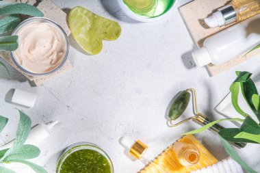 Doğa Yaşlanma Karşıtı Kozmetik, Terapi Masajı. Asya güzellik bakımı. Yeşim silindir, gua sha masaj aleti çeşitli organik serumlar, jel, bitkisel özler, spa havluları. Beyaz mermer arka planda düz alan