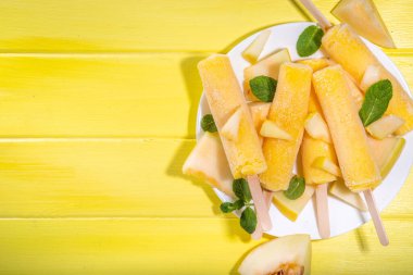  Kavunlu dondurma, tatlı şerbet lolipopu, çubuklarda ev yapımı dondurma, taze kavun dilimleri ve nane yaprakları. 