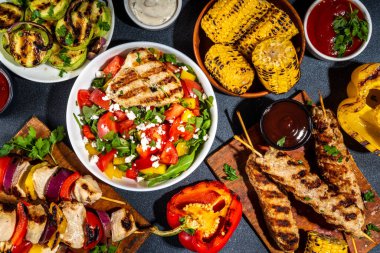 Izgara yaz bbq tabakları. Barda piknik pikniği çeşitli ızgara yiyeceklerle - şiş kebap şiş şiş, ızgara mısır, kızarmış tavuk salata, biftek, sosis, sebze